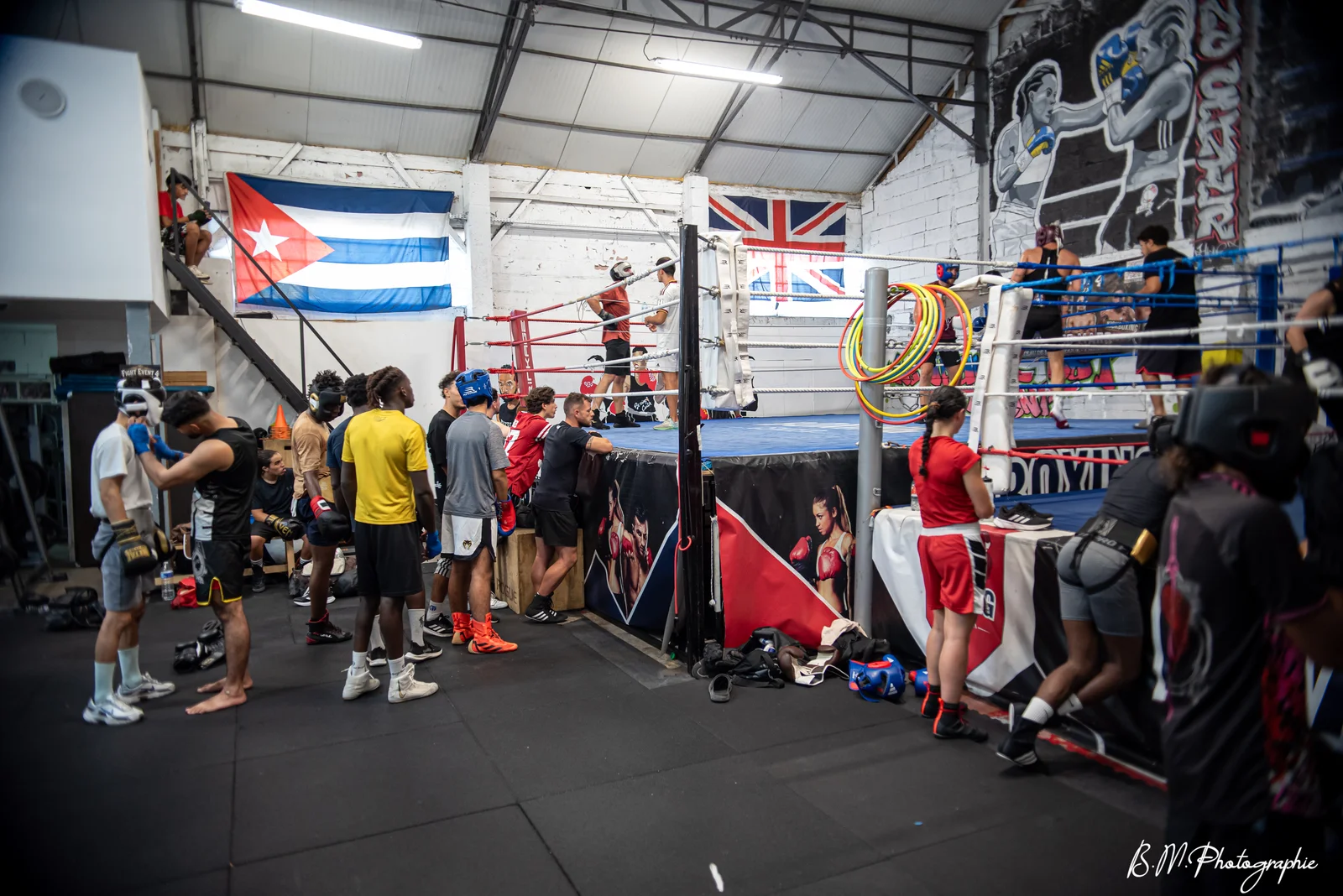 Boxeurs et pratiquants préparant leurs gants et bandages au pied du ring de boxe anglaise